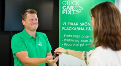 En kvinne overleverer bilnøkler til en mann.